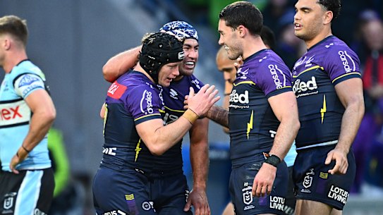 Harry Grant of the Storm, black helmet, celebrates with Jahrome Hughes and other teammates after scoring a try.