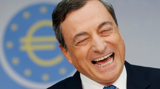 Then president of European Central Bank Mario Draghi, laughs during a news conference in Frankfurt in 2014.