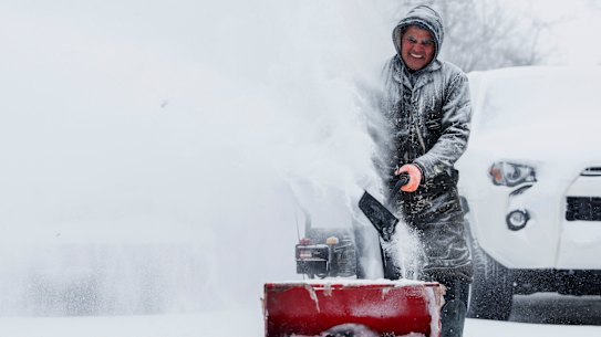 Francisco Erazo uses his snow blower to clear snow in Michigan.