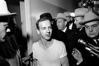 Surrounded by detectives, Lee Harvey Oswald talks to the media as he is led down a corridor of the Dallas police station for another round of questioning on November 23, 1963.