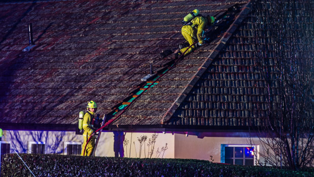 Firefighters on the roof of a house in Mugga Way on Thursday morning.