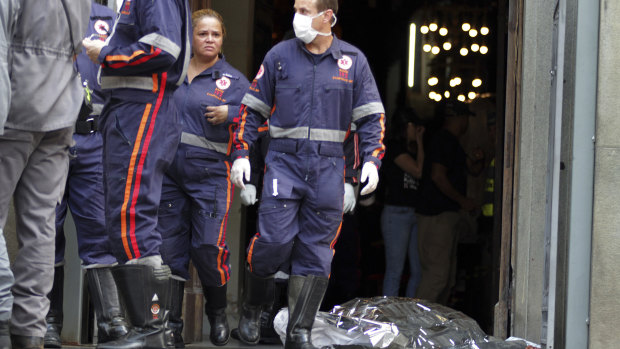 A firefighter walks next to a victim killed at the Metropolitan Cathedral in Campinas, Brazil, on Tuesday.