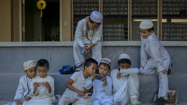 Students in a Muslim school play with their mobile devices in Zamboanga.