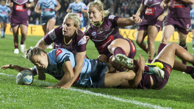 No stopping her: Isabelle Kelly defies the Maroons opposition to score her second try to seal victory for the Blues.