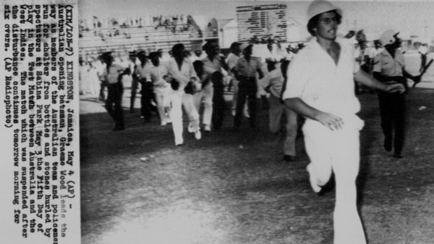 Scan from AP radiogram image in the SMH Archive. Australian opening batsman, Graeme Wood leads the way as members of the Australian team and policemen run for shelter from bottles and stones hurled by spectators at Sabina Park May 3 the Fifth Day of play in the Test Match between Australia and the West Indies.