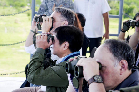 Watching out for trouble in the South China Sea:  Australian Defence Minister Richard Marles, left, and Philippine President Ferdinand Marcos jnr, centre, watch the combined amphibious assault exercise on Friday.