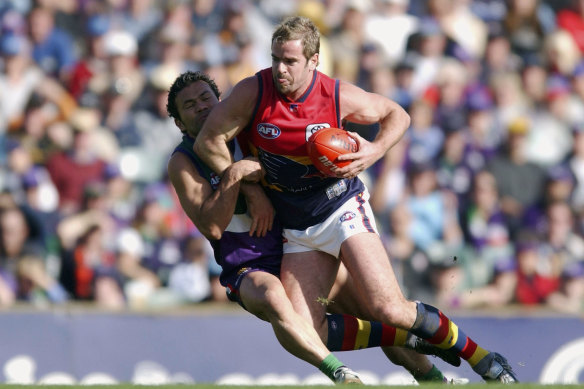 Mark Ricciuto of the Crows is tackled by Peter Bell of the Dockers.