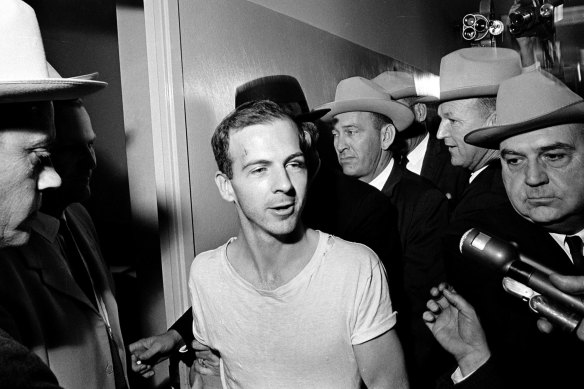 Surrounded by detectives, Lee Harvey Oswald talks to the media as he is led down a corridor of the Dallas police station for another round of questioning on November 23, 1963.