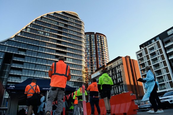 Construction workers at Mirvac’s Green Square site in Sydney wait for rapid COVID-19 tests before starting work.