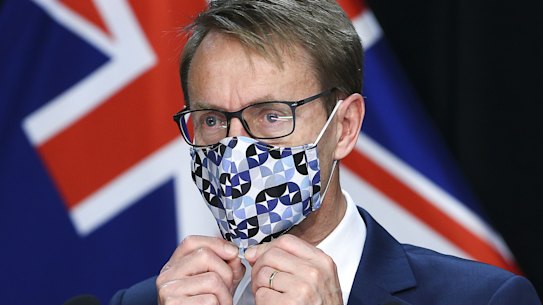 NZ Director-General of Health Dr Ashley Bloomfield puts a face mask on during a press conference on Friday.
