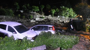 Capsized cars as seen the roads of after they were hit by a landslide in Casargo, near the northern Italian town of Lecco.