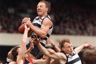Gary Ablett soars over teammate Bill Brownless and Melbourneâ€™s Steven Febey.