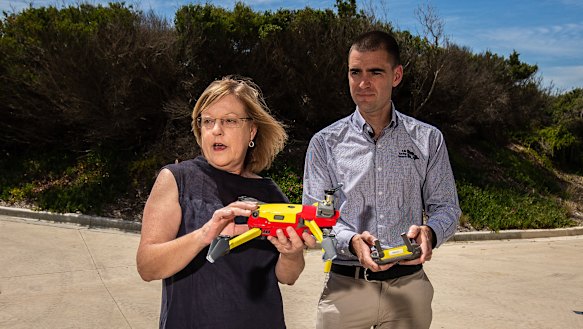 Lisa Neville and Kane Treloar holding a Lifesaving Victoria drone at a beach in Ocean Grove.