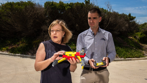 Lisa Neville and Kane Treloar holding a Lifesaving Victoria drone at a beach in Ocean Grove.