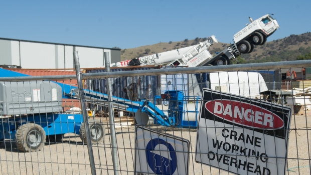 The driver's cab of the mobile crane points skyward after its heavy boom crashed to the ground in Hume on Friday.