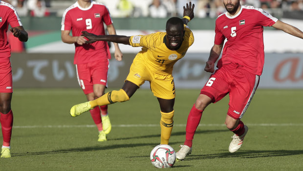 Socceroos winger Awer Mabil and Palestine defender Tamer Salah fight for the ball.