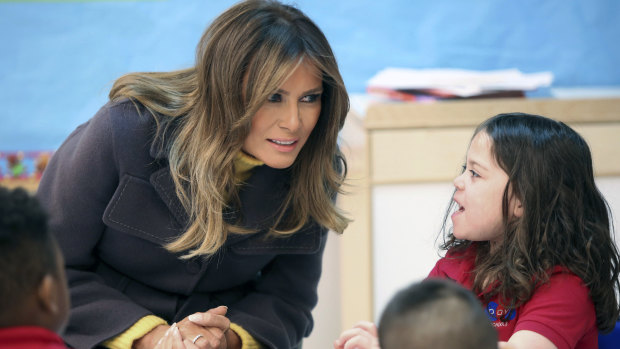 Melania Trump talks with a pre-kindergarten student during a visit to a Tulsa school.