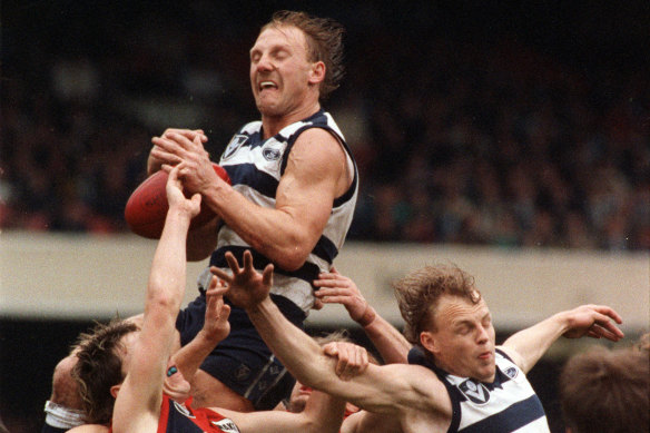 Gary Ablett soars over teammate Bill Brownless and Melbourne’s Steven Febey.
