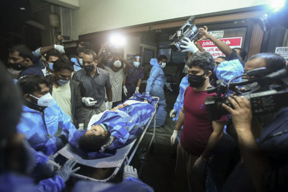 A passenger is treated after an Air India Express flight skidded off the runway while landing.