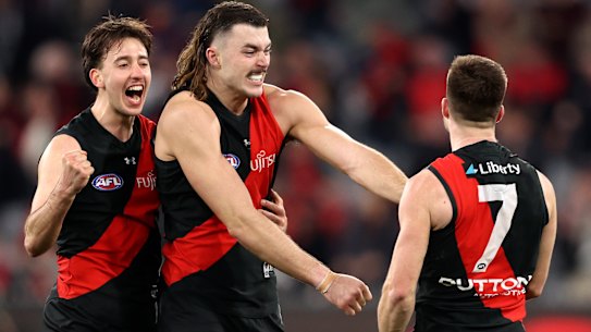 Essendon players celebrate on the fial siren.