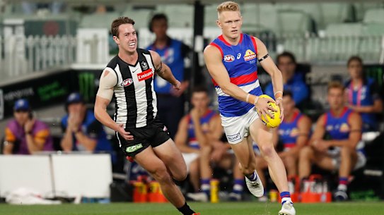 MELBOURNE, AUSTRALIA - MARCH 19: Adam Treloar of the Bulldogs is chased by Tyler Brown of the Magpies during the 2021 AFL Round 01 match between the Collingwood Magpies and the Western Bulldogs at the Melbourne Cricket Ground on March 19, 2021 in Melbourne, Australia. (Photo by Michael Willson/AFL Photos via Getty Images)