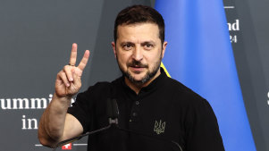 Ukraine’s President Volodymyr Zelensky flashes a V sign after his closing press conference during the Summit on Peace in Ukraine