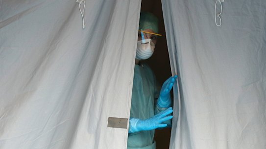 A medical staffer watches from a tent at one of the emergency structures set up at the Brescia hospital in northern Italy.