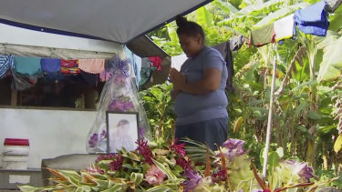 A woman prays in front of a portrait of her child lost to measles in Apia, Samoa, earlier this month.