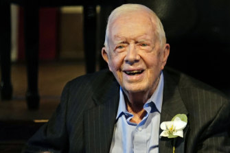 Former US president Jimmy Carter smiles as his wife Rosalynn speaks at their 75th wedding anniversary celebrations last July.