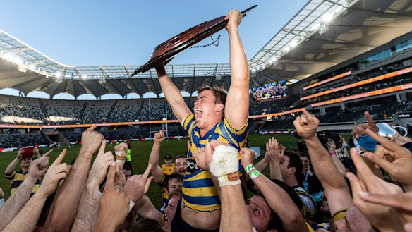 Guy Porter lifts the Shute Shield after Sydney University's victory last season. 