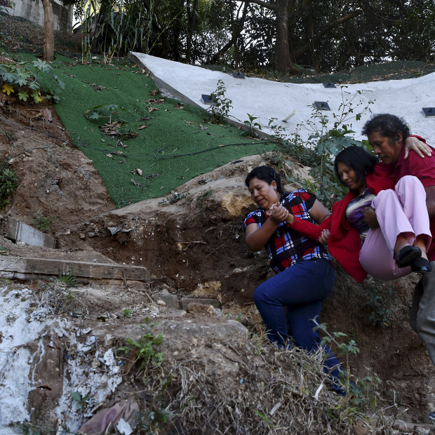 Flory Teletor, a victim of gun violence, needs to be carried up the steps to the street above her sister and brother-in-law’s house in Guatemala City.