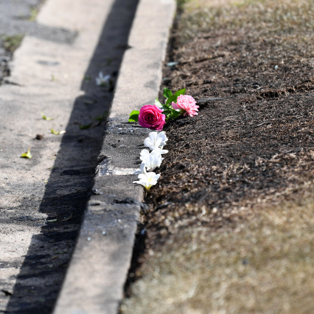 Flowers are left at the scene of the car fire.