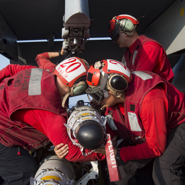 Sailors prepare to load munitions onto an F/A-18E Super Hornet assigned to the Sidewinders of Strike Fighter Squadron 86 on the flight deck of the aircraft carrier USS Dwight D. Eisenhower.