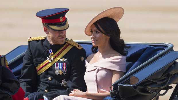 Prince Harry, and Meghan, the Duke and Duchess of Sussex ride in a carriage during the Trooping the Colours ceremony at Horse Guards Parade as the Queen celebrates her official birthday, in London, on Saturday.