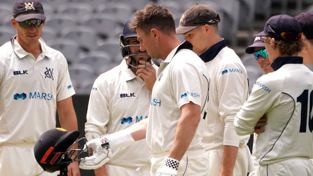 Western Australia's Shaun Marsh inspects his helmet after being struck at the MCG during the Sheffield Shield match that was ultimately abandoned.