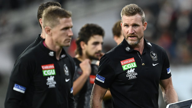 Magpies coach Nathan Buckley talks to his coaching staff during the Anzac Day clash with Essendon at the MCG.