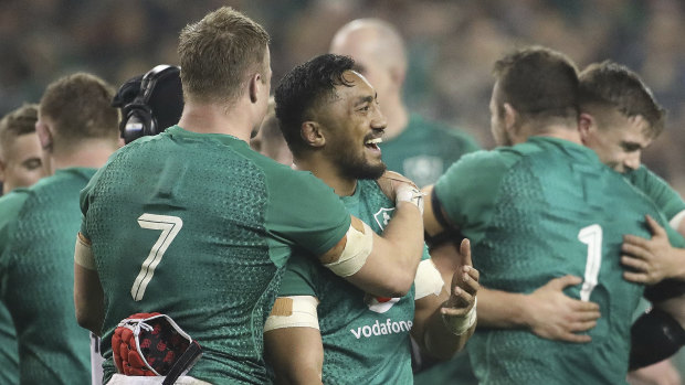 Changing of the guard: Josh van der Flier and Ireland's Kiwi-born Bundee Aki embrace after beating the All Blacks.