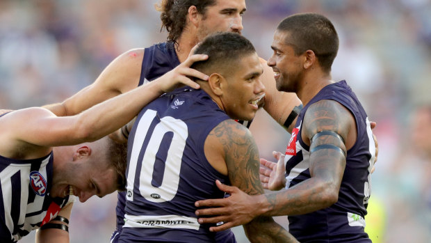 Michael Walters (centre) is congratulated by Dockers teammates after scoring one of his three goals against the Roos.