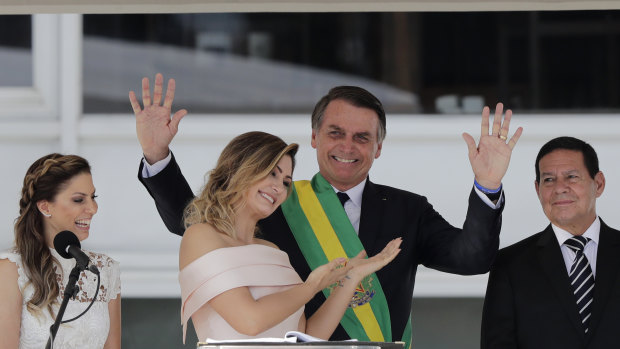 Brazil's new first lady Michelle Bolsonaro points at her husband, Brazil's new President Jair Bolsonaro, after she gave her speech in sign language.