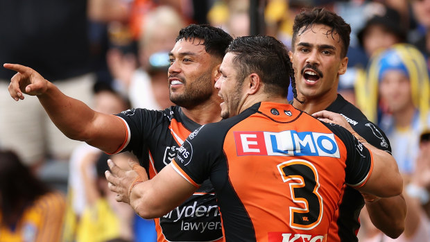 David Nofoaluma celebrates a Tigers try with James Roberts and Daine Laurie.