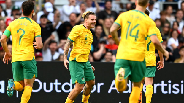 Jason Cummings celebrates a goal on debut for the Socceroos.