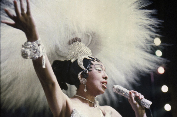 Josephine Baker holds a rhinestone-studded microphone as she performs during her show “Paris, mes Amours” at the Olympia Music Hall in Paris in 1957.