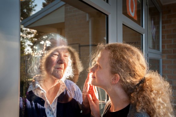 Margaret Wheeler greets her granddaughter Alice through the glass of her aged care facility in Victoria last year. 