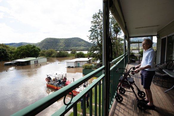 Patricia Parker, 86, views her submerged home from the safety of her son and daughter-in-law's balcony at Nagles Gully, on the Hawkesbury River where the flood waters continue to rise near Wisemans Ferry. 24th March 2021 Photo: Janie Barrett