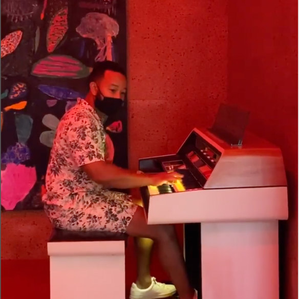 John Legend playing the piano in Christiansen’s music room.   