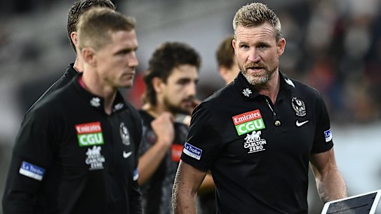 Magpies coach Nathan Buckley talks to his coaching staff during the Anzac Day clash with Essendon at the MCG.