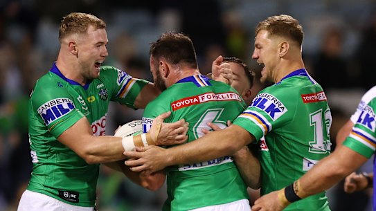 Matt Frawley is mobbed by his Canberra teammates after scoring a try.