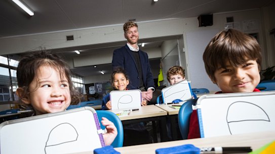 Port Melbourne Primary School prep students Brooklyn, Chloe, Felix and Gonzalo use an explicit instruction approach to learning to read with principal Tom Cain.
