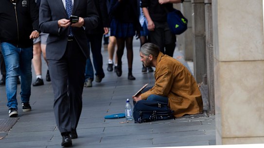 The haves and have not ... a man begs in Collins Street, Melbourne.
