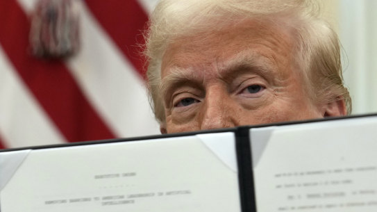 Donald Trump holds up one of the many executive orders signed last week.
